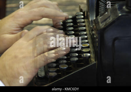 Fingers printed on old writing machine. Moved picture of the hands over the typing keyboard. Stock Photo