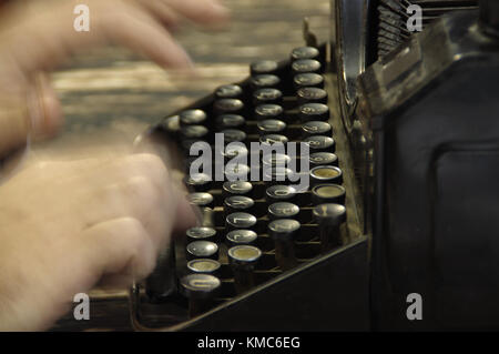 Fingers printed on old writing machine. Moved picture of the hands over the typing keyboard. Stock Photo