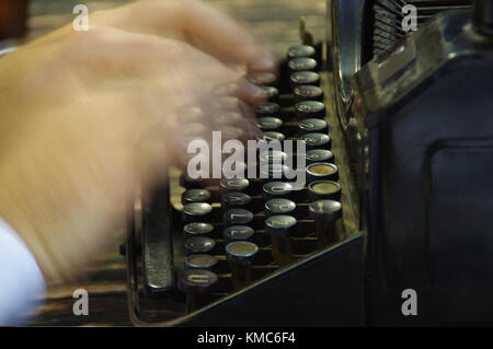 Fingers printed on old writing machine. Moved picture of the hands over the typing keyboard. Stock Photo