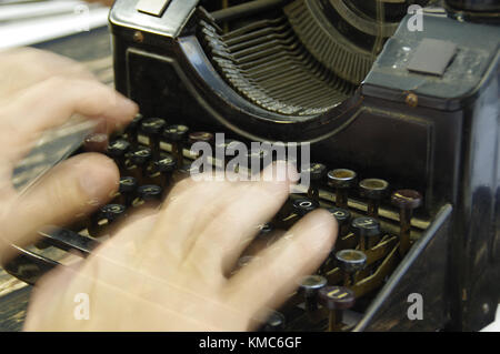 Fingers printed on old writing machine. Moved picture of the hands over the typing keyboard. Stock Photo