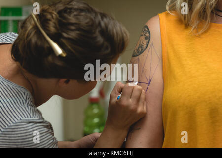 Professional tattoo artist makes a tattoo on a womans hand Stock Photo