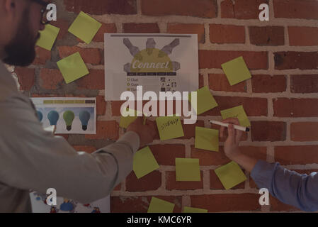 Executives discussing over sticky notes Stock Photo