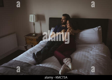 Happy couple relaxing on bed in bedroom Stock Photo