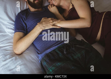 Couple sleeping together on bed in bedroom Stock Photo
