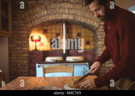 Man cutting bun with knife Stock Photo