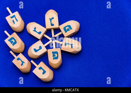 Dreidels for Hanukkah wooden tops on a blue background Stock Photo