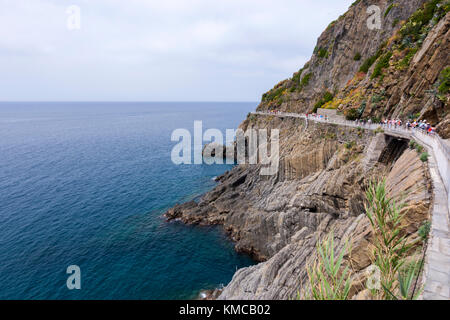 Hikers along the hiking trail Via dell' Amore (Lovers’ lane) a path along Cinque Terre coastline, province of La Spezia, Liguria region, Italy. Stock Photo