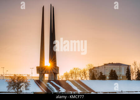 Vitebsk, Belarus. Sun Shines Through Main Monument Three Bayonets Of Memorial Of Liberators Near Victory Park. Monument To Heroes Who Died In Battles  Stock Photo
