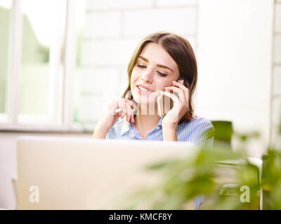 beautiful young caucasian businesswoman talking on mobile phone, happy and smiling. Stock Photo