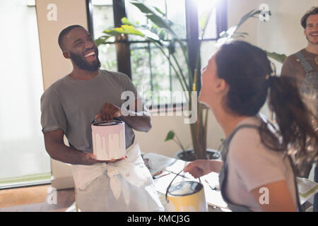 Laughing young couple painting living room Stock Photo
