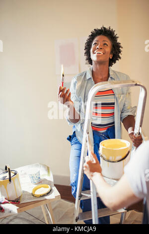 Smiling woman painting living room Stock Photo