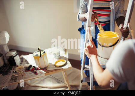 Women with yellow paint painting living room Stock Photo