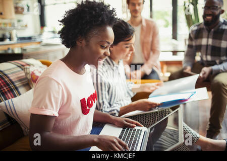 Creative business people meeting, using laptop and reading paperwork Stock Photo