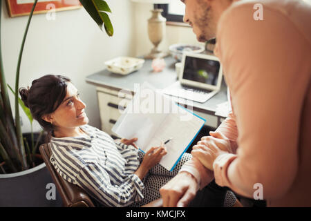 Businesswoman discussing paperwork with colleague in office Stock Photo