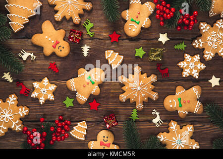 Christmas gingerbread cookies homemade on wooden table with candies and New Year decorations. Xmas background Stock Photo