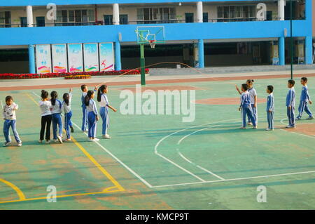 In the primary school playground, primary school students are taking sports classes and skipping rope. In Shenzhen, China. Stock Photo