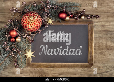 Decorated blackboard with text 'Feliz Navidad', or 'Merry Christmas' in Spanish on oak wood background Stock Photo