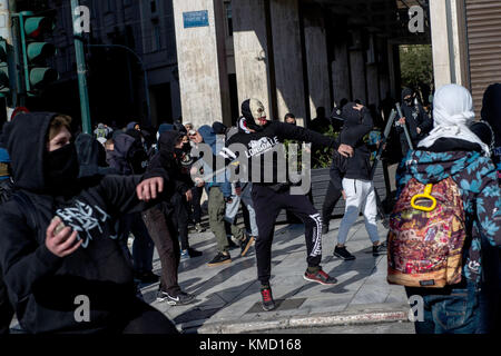 Athens, Greece. 6th Dec, 2017. Masked people can be seen partaking in a protest match in Athens, Greece, 6 December 2017. The ninth anniversary of the death of a 15 year old by police bullet was marked by riots. Some 200 masked persons threw stones against the police, devastated shops and cafés and lit some trash containers on fire. Credit: Angelos Tzortzinis/dpa/Alamy Live News Stock Photo