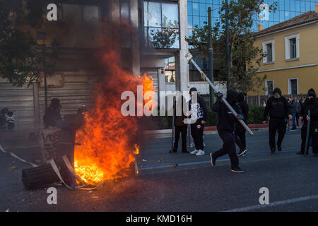 Athens, Greece. 6th Dec, 2017. Masked people can be seen partaking in a protest match in Athens, Greece, 6 December 2017. The ninth anniversary of the death of a 15 year old by police bullet was marked by riots. Some 200 masked persons threw stones against the police, devastated shops and cafés and lit some trash containers on fire. Credit: Angelos Tzortzinis/dpa/Alamy Live News Stock Photo