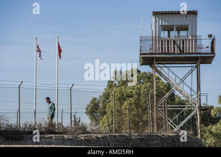 A man takes a walk under a watchtower of the U.N. in the northern buffer zone that separates turkish and cypriot sides of Nikosia city. After the occupation of Cyprus by turkish troops in 1974, Nikosia was separated in two zones, Turkey controlling the north side and Cyprus the south. 3rd Dec, 2017. Credit: Celestino Arce/ZUMA Wire/Alamy Live News Stock Photo