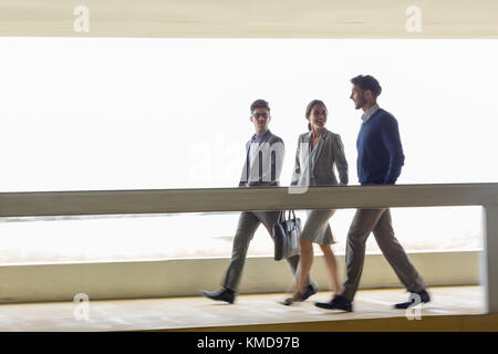 Business people walking and talking along walkway Stock Photo