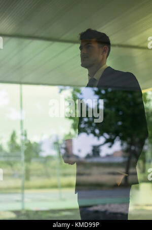 Pensive businessman looking out office window Stock Photo