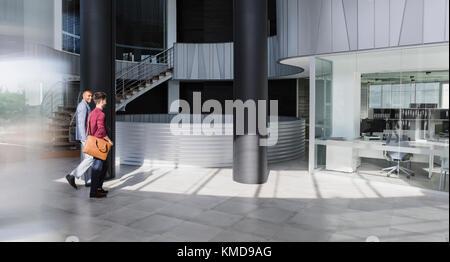 Businessmen walking in modern office lobby Stock Photo