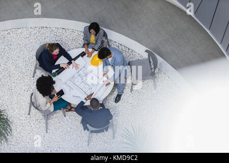 Architects reviewing blueprints,planning at table Stock Photo