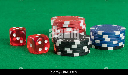 two red dices and different chips on green background. gambling and betting addiction concept Stock Photo