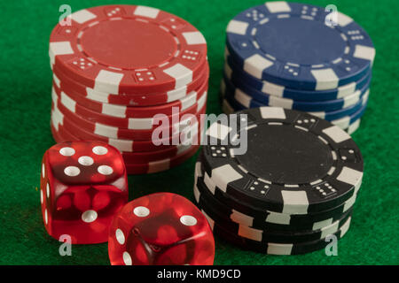 two red dices and different chips on green background. gambling and betting addiction concept Stock Photo