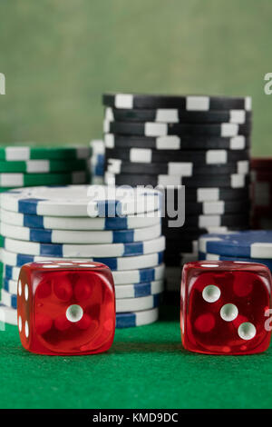 two red dices and different chips on green background. gambling and betting addiction concept Stock Photo