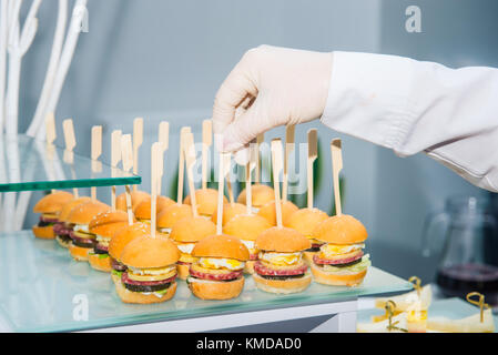 The waiter is servering catering buffet table with food and snacks for ...