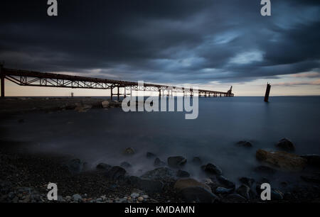 Seascape with jetty during a dramatic cloudy sunset  at Xeros area in Northern Cyprus