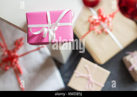 Many self made present boxes on floor, focus on little pink present box Stock Photo