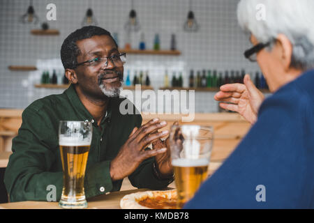 senior friends having discussion at bar Stock Photo