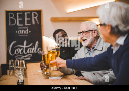 senior friends drinking beer together Stock Photo