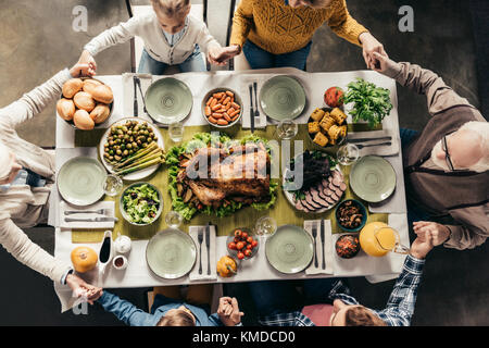 family praying before holiday dinner Stock Photo