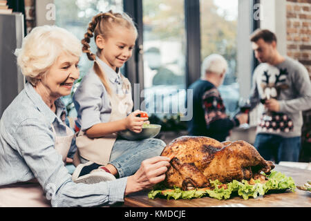 grandmother and granddaughter with turkey for holiday dinner Stock Photo