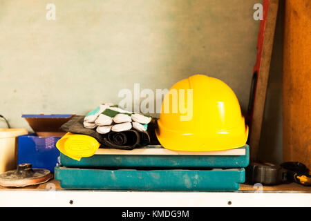 Attic construction and renovation tools, yellow safety helmet, gloves, tool box, measuring tape and other tools. Stock Photo