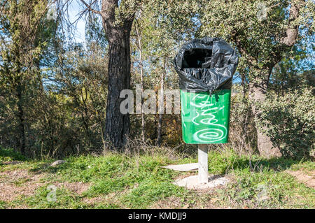 green trash with trash bag tied outside Stock Photo
