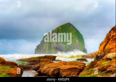 Looking out at haystack rock from the rocky shores of Cape Kiwanda in Pacific City on the Oregon Coast Stock Photo