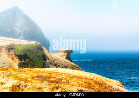 A view of the Pacific Ocean and the top of Haystack Rock from on top of the sandstone cliffs of Cape Kiwanda in Pacific City on the Oregon Coast Stock Photo