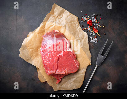 Raw meat steak with spices on rusty background Stock Photo
