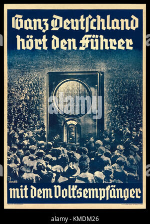 “Ganz Deutschland hört den Führer mit dem Volksempfänger” (All over Germany hear the leader with the people's receiver) 1936 Nazi Germany propaganda poster featuring a photograph of a crowd of Germans at a Nuremberg Rally surrounding an oversized Volksempfänger VE301 radio receiver which was developed on instruction by Propaganda Minister Joseph Goebbels and when on sale in 1933. See more information below. Stock Photo