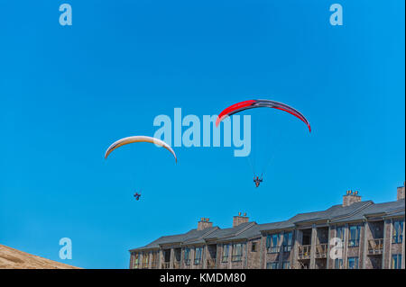 Hang gliders guide their kites over the row of condos at Pacific City on the Oregon Coast. Stock Photo
