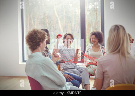 Group therapy session doing team building exercise with yarn Stock Photo