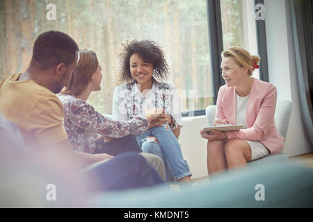Smiling woman comforting woman in group therapy session Stock Photo