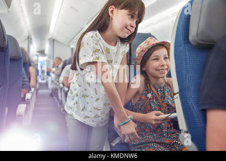 Girl sisters playing video game on airplane Stock Photo