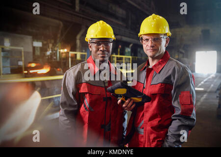Portrait confident steelworkers with digital tablet in steel mill Stock Photo