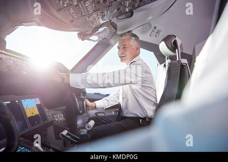 Smiling male pilot in airplane cockpit Stock Photo